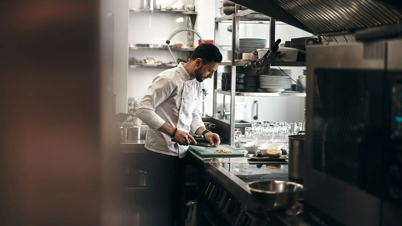 A chef preparing food in a busy restaurant kitchen